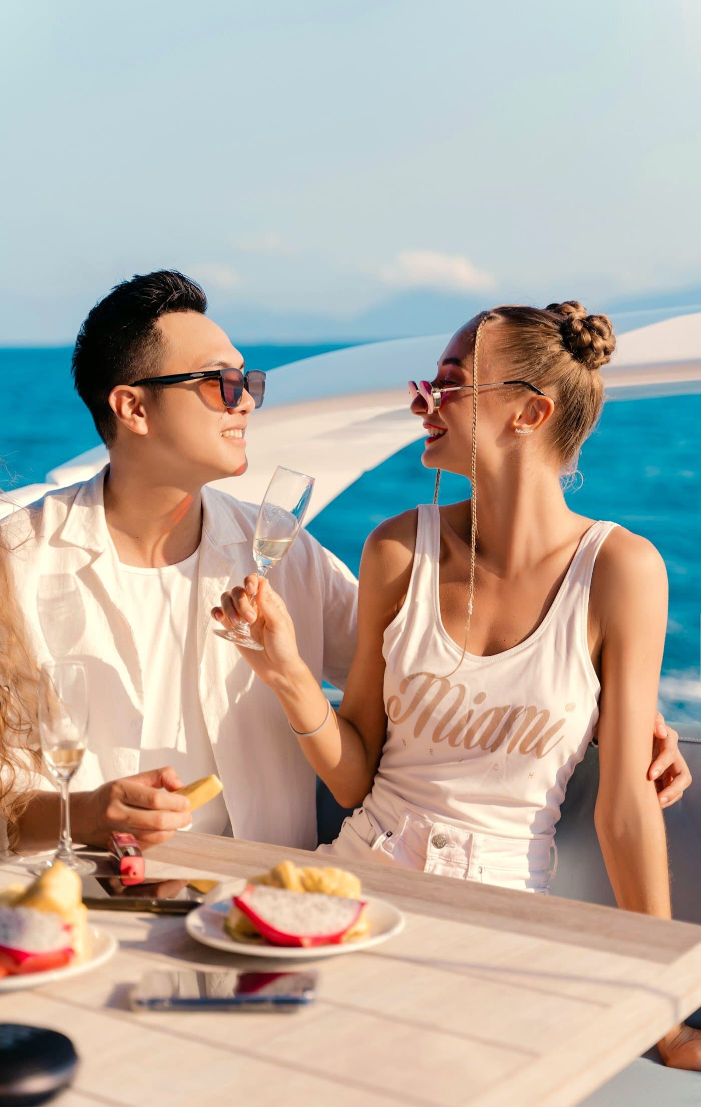 Young couple enjoying lunch and champagne on deck at sea