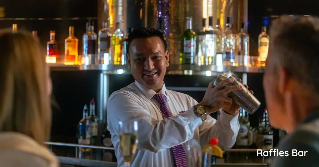 Bartender preparing a cocktail at Raffles Bar on an Ambassador Cruises ship